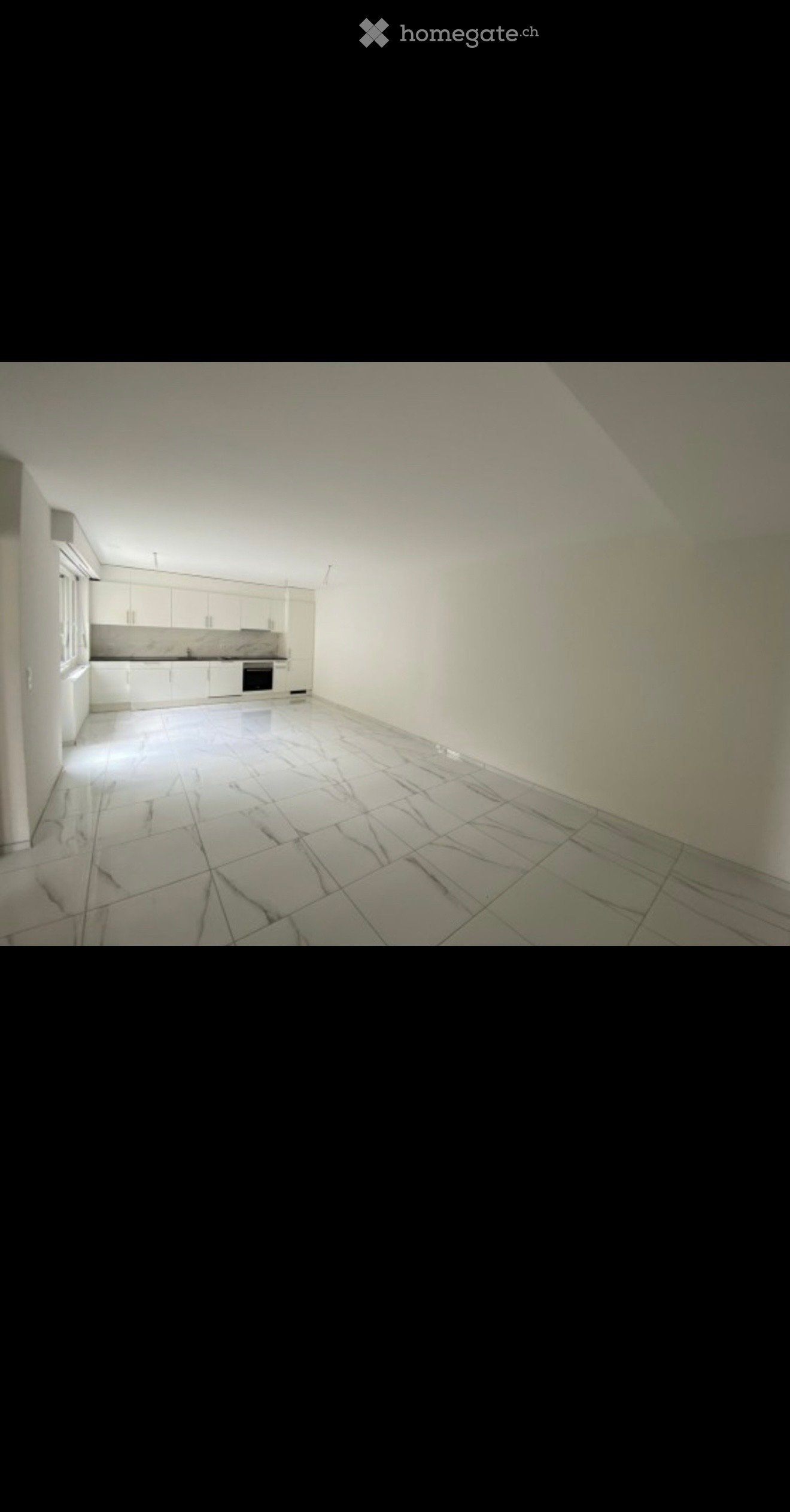 Empty kitchen with white cabinets, tiled floor, and basic appliances like a sink and oven, but no furniture or personal items.