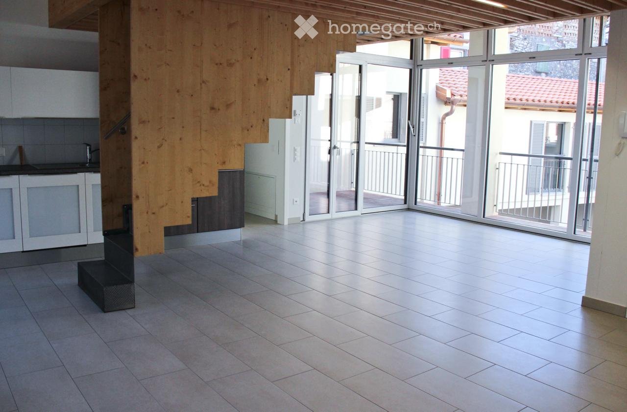 Empty room with tiled floor, white cabinets, and large glass doors leading to a balcony.