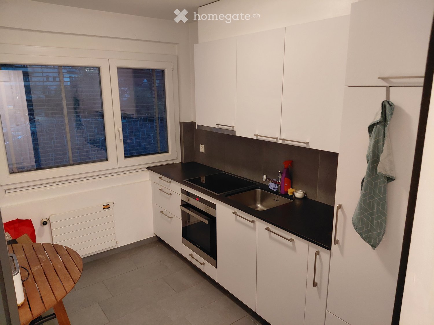 {"type": "Kitchen", "objects": ["table", "oven", "sink", "faucet", "faucet handle", "oven handle", "oven control panel", "oven door", "oven knob", "oven light", "oven indicator", "oven door handle", "oven door knob", "oven door light", "oven door indicato