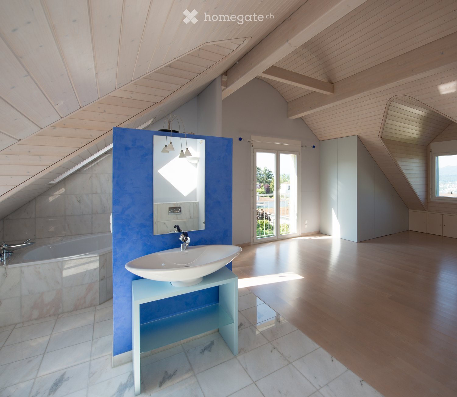 Spacious bathroom with vaulted ceiling, white walls, blue vanity unit, large mirror, and tiled floor