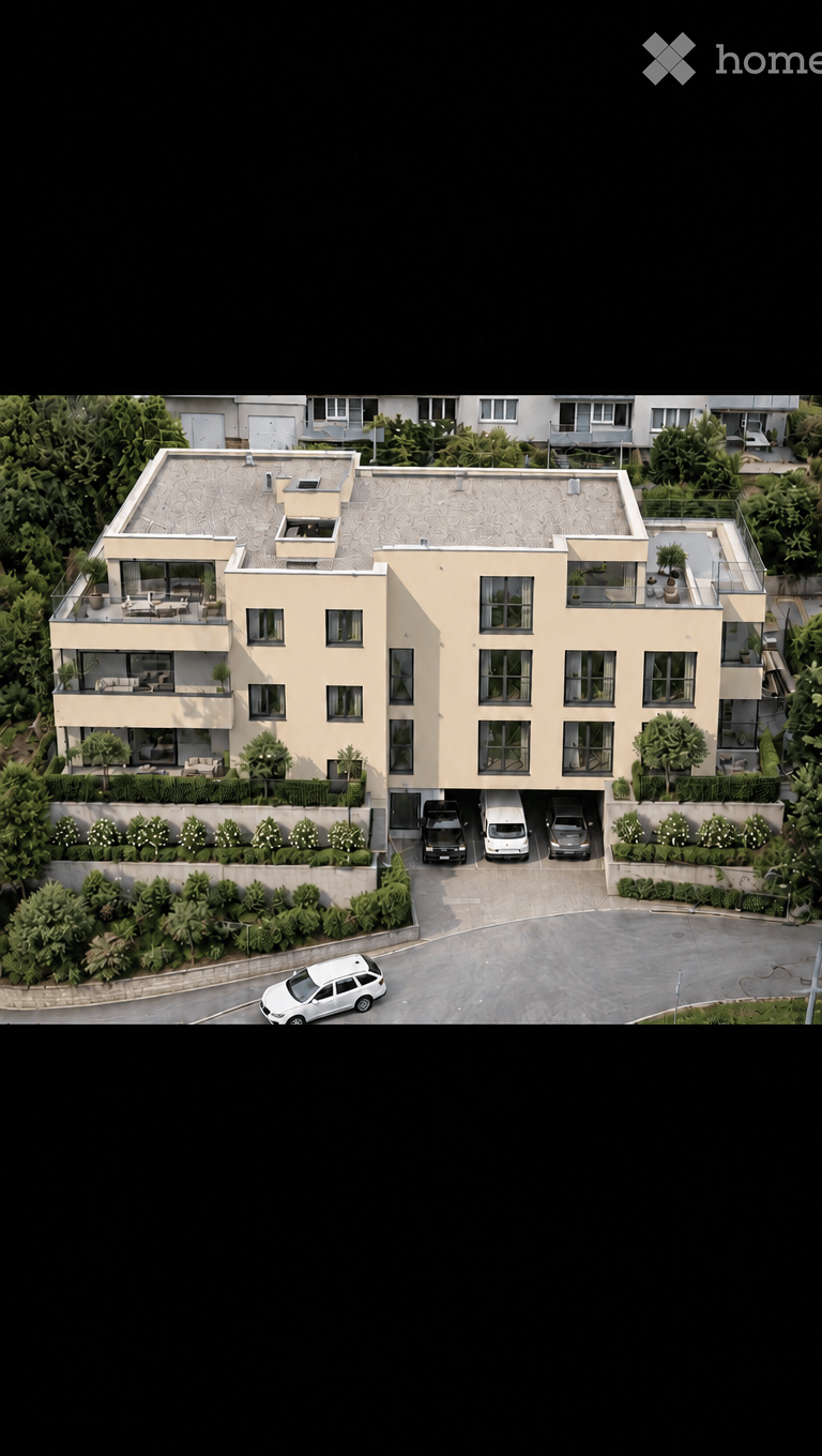 Modern multi-story residential building with balconies, garage, and parking area.
