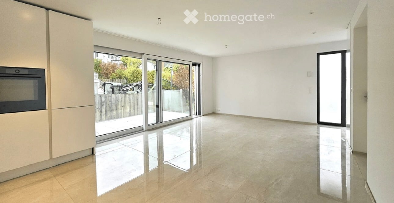 Empty room with tiled flooring, large sliding glass doors leading to an outdoor area, and built-in cabinetry on one side.