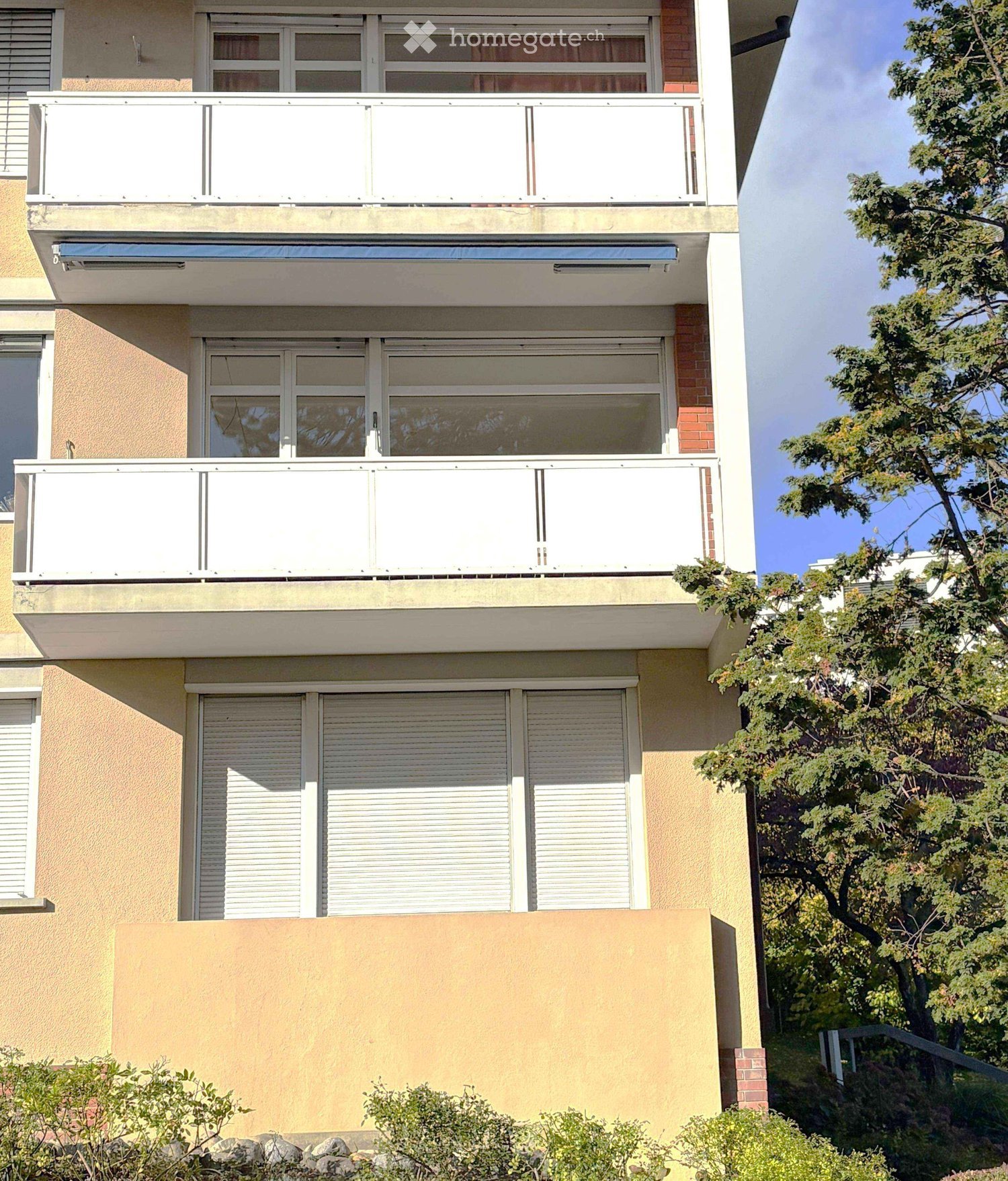 Multi-story building with balconies, large windows, and modern design.