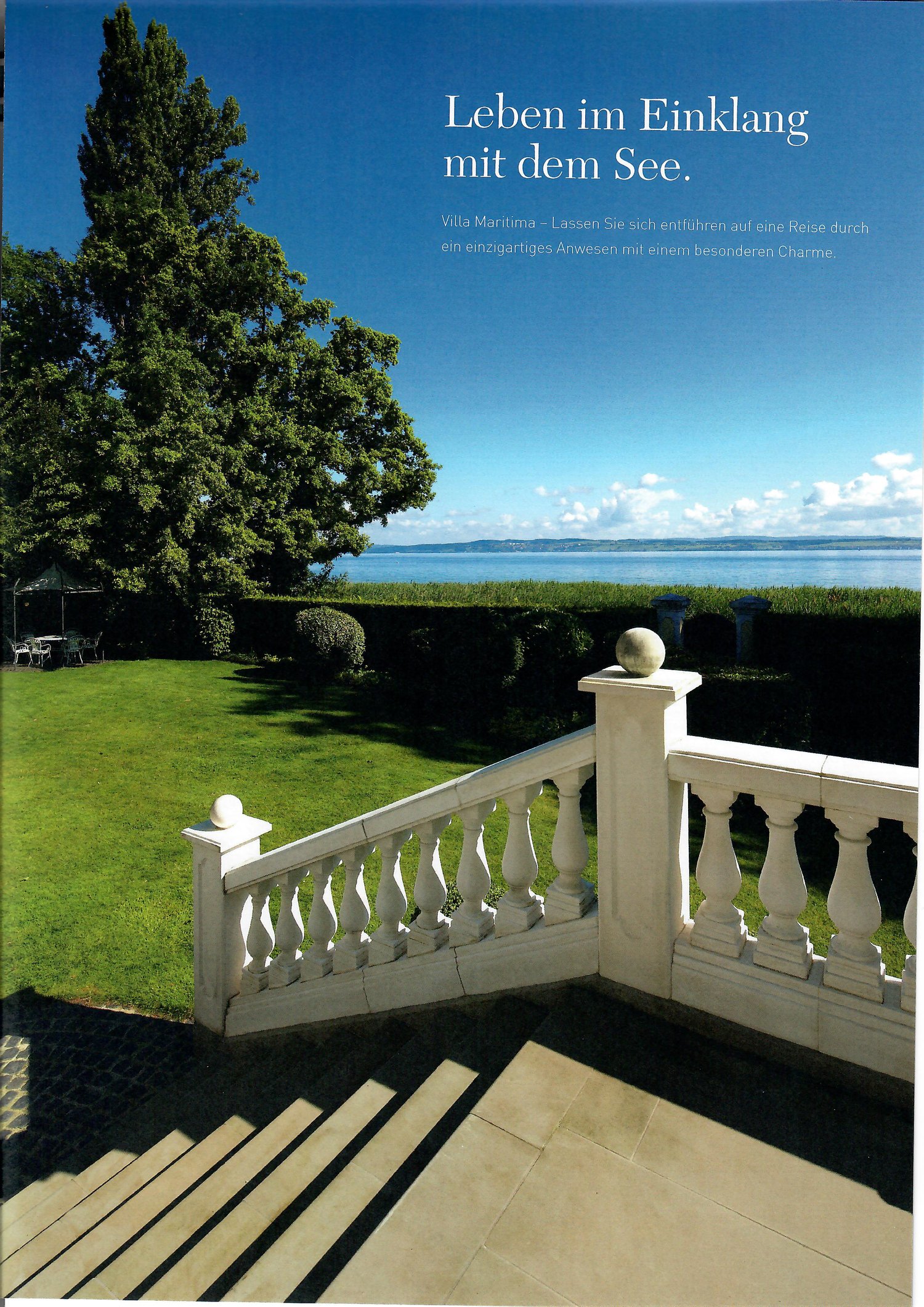 white wooden railing, green lawn, large tree, beach and ocean visible