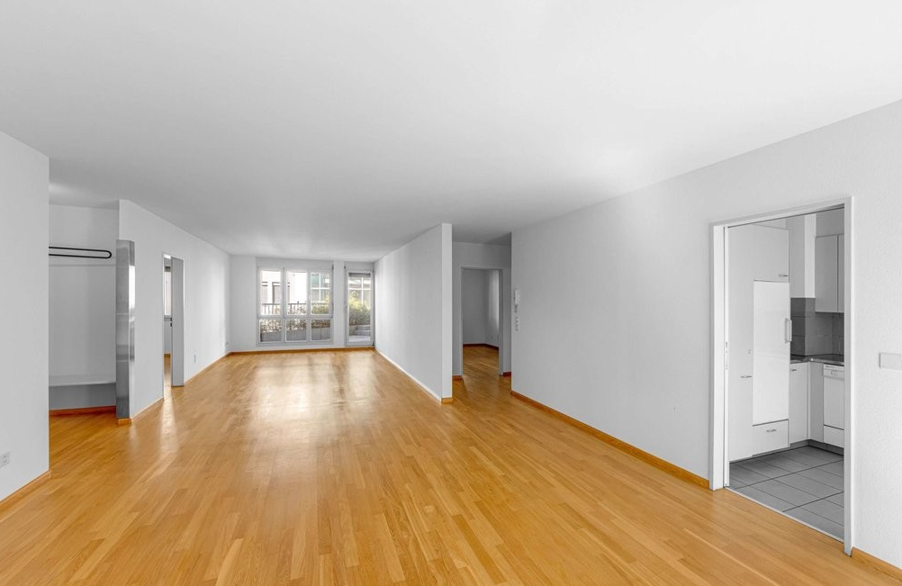 empty room with hardwood floors, large windows, balcony
