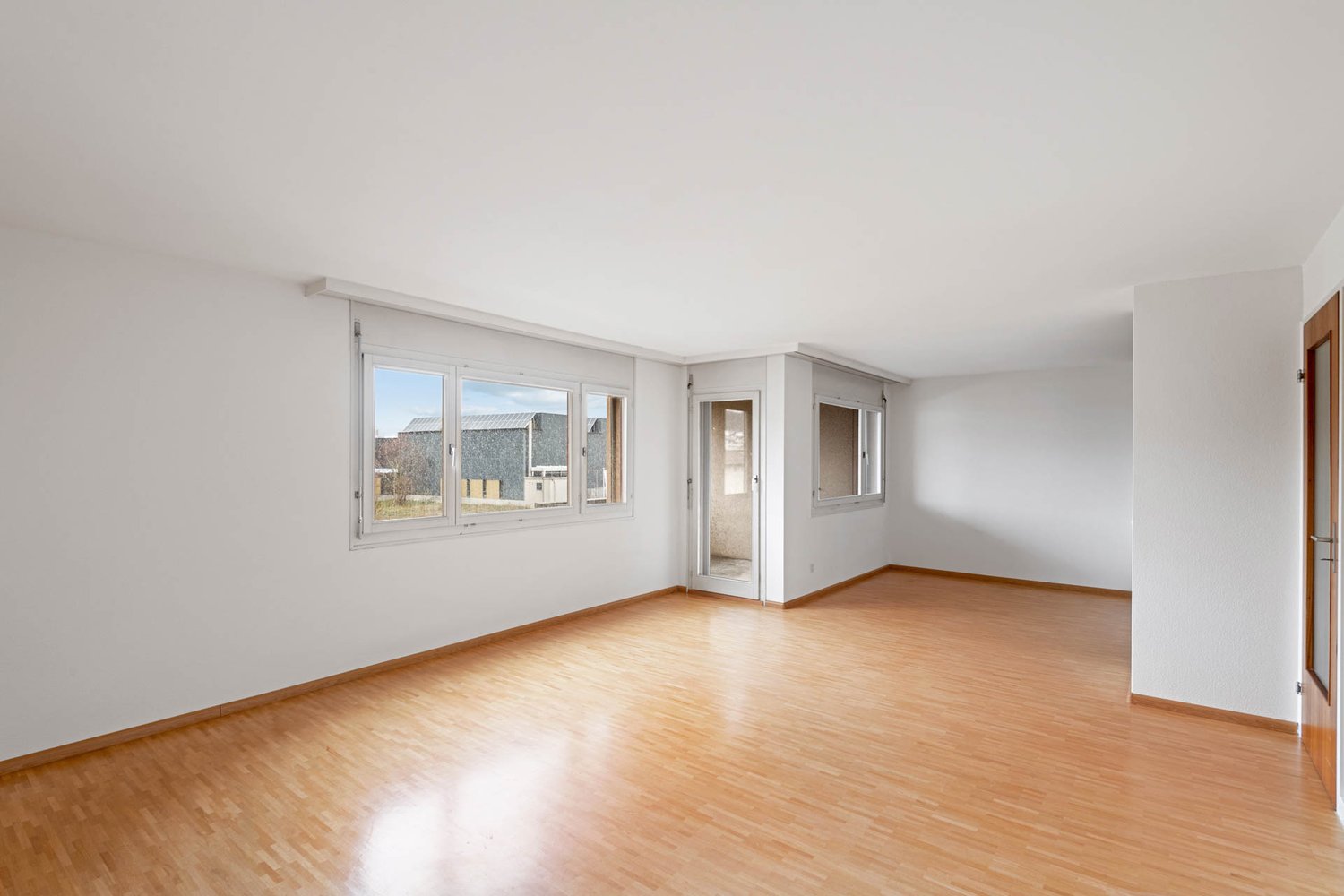 empty room with large windows, hardwood floors, sliding door