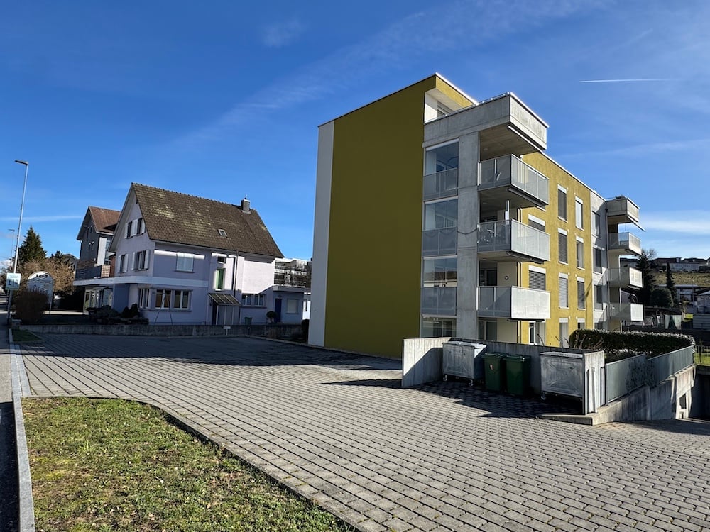 Modern apartment building with yellow facade, brick apartment building, brick sidewalk, brick paving