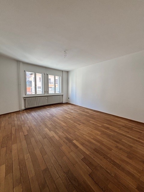 empty room, wooden floor, white walls, windows, radiator