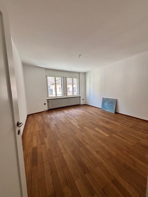 empty room, wooden floor, white walls, windows, radiator