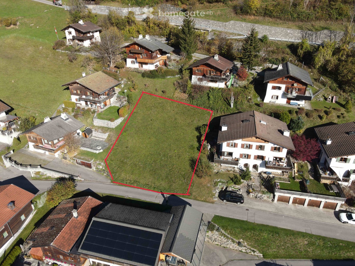 Plot of land marked by a red square, multiple houses around it