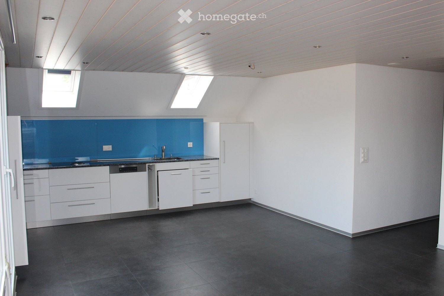 kitchen area, white cabinets, blue backsplash, tiled floor, sink, dishwasher, white ceiling, two skylights