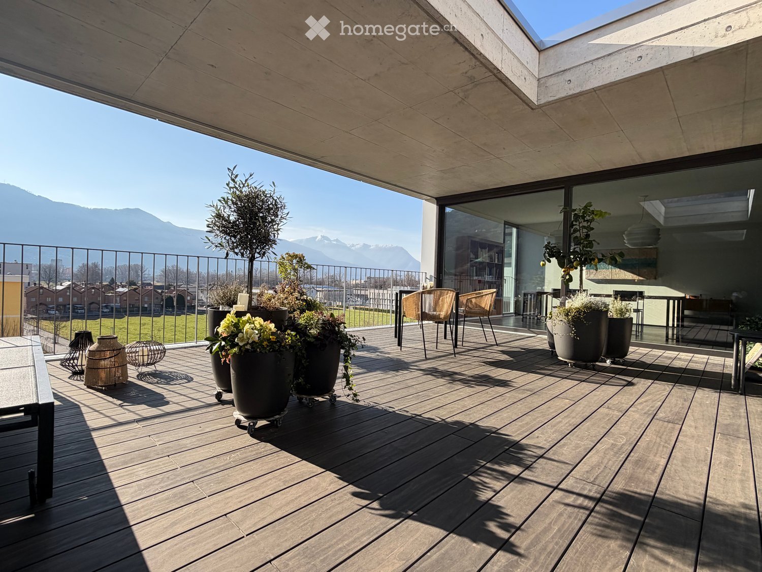 elevated terrace, railings, chairs, tables, plants, mountain view