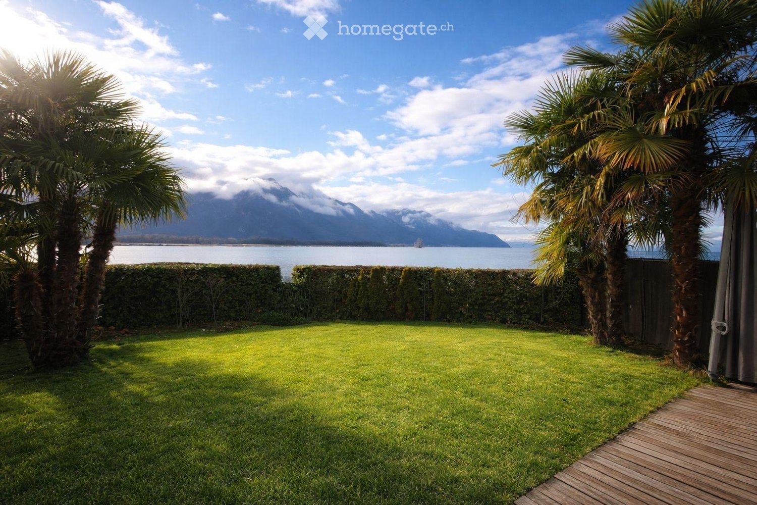 well-maintained lawn, hedges, palm trees, wooden deck, view of the lake and mountains