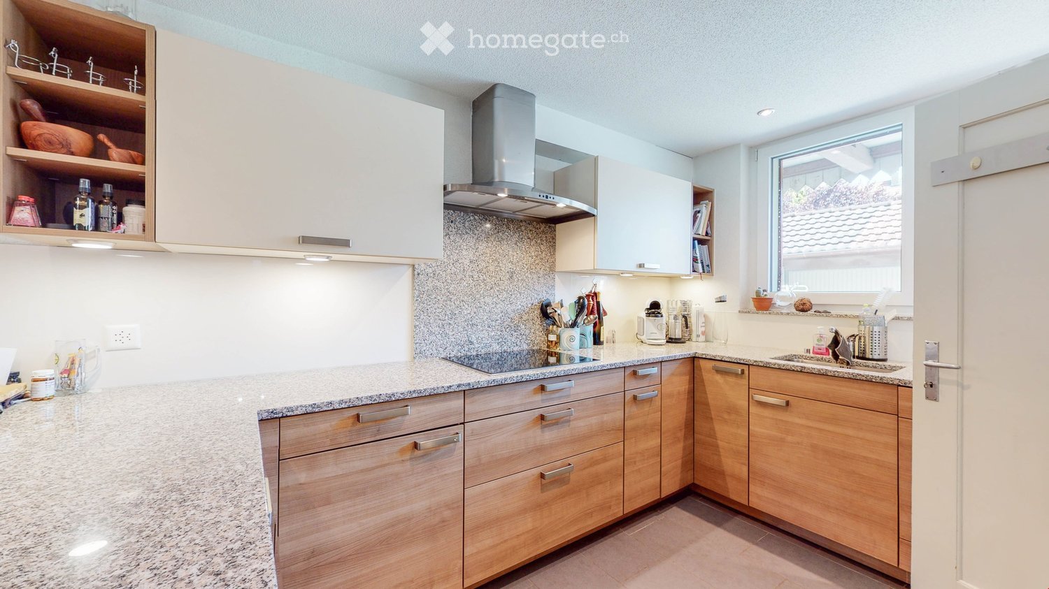 modern kitchen with granite countertops, wooden cabinets, gas stove, extractor hood, sink, window
