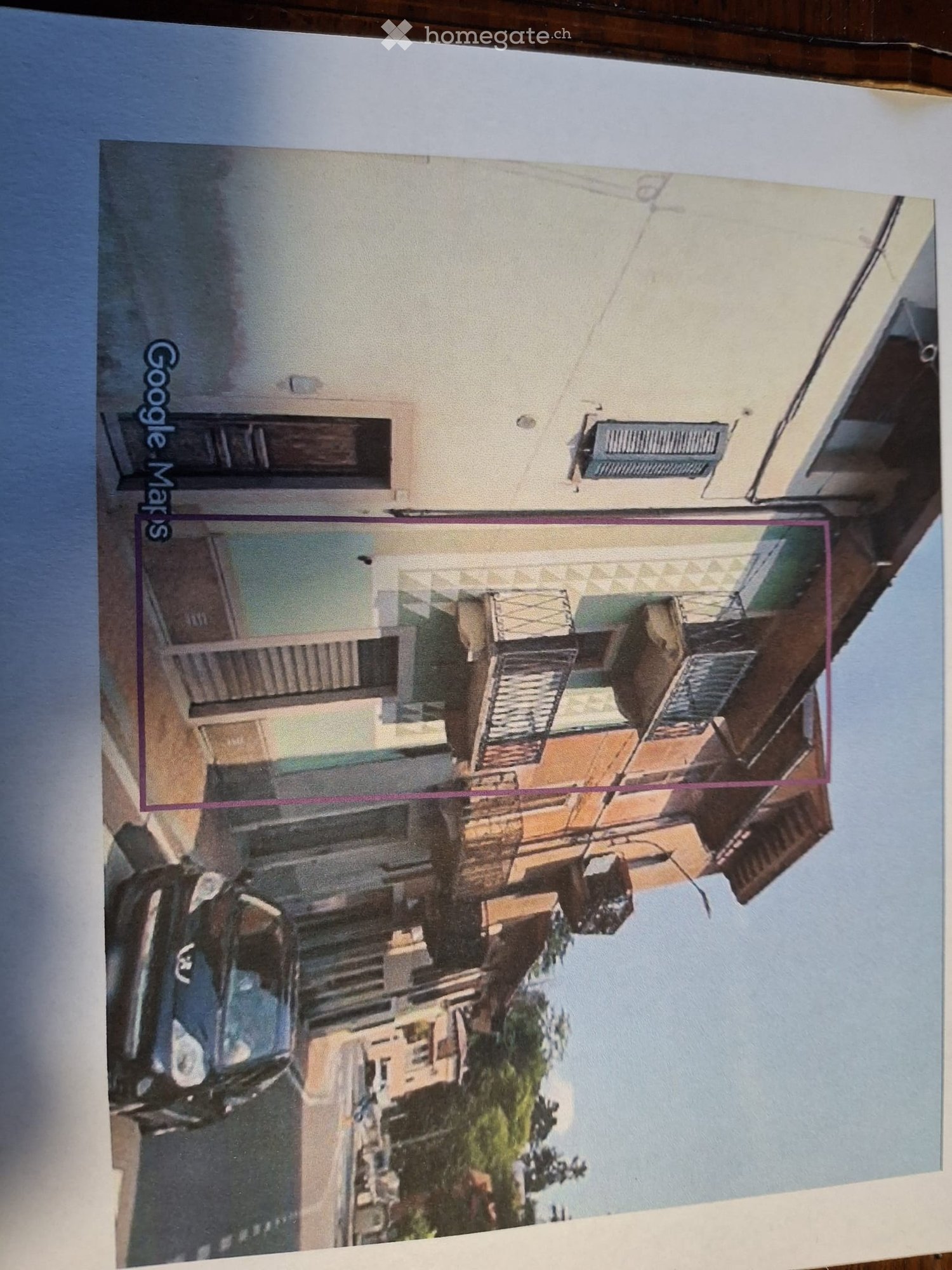 3 story building, multiple balconies, windows, car parked in front
