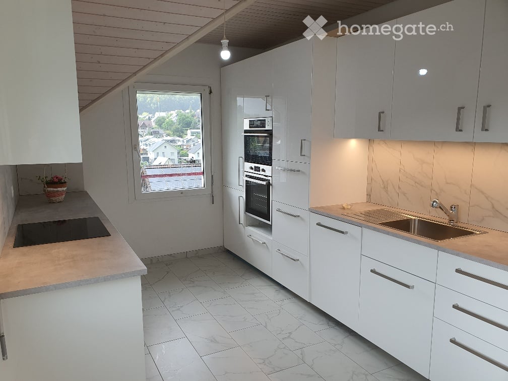 Kitchen. Modern kitchen with white cabinets, marble countertops, induction cooktop, and built-in oven and microwave.