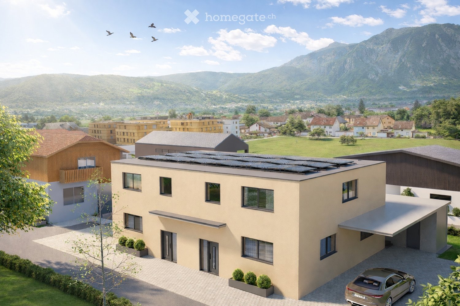 House. A modern two-story house with a flat roof, large windows, and solar panels on the roof. The house is surrounded by a well-maintained garden and is situated in a scenic, mountainous area with other houses and greenery in the background.
