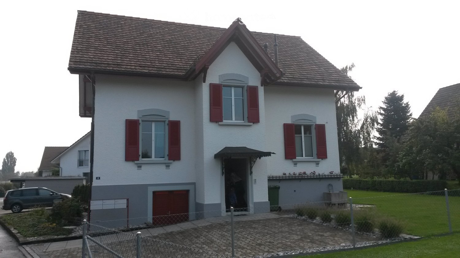 2 story house, white walls, red shutters, brown roof, red garage, front driveway