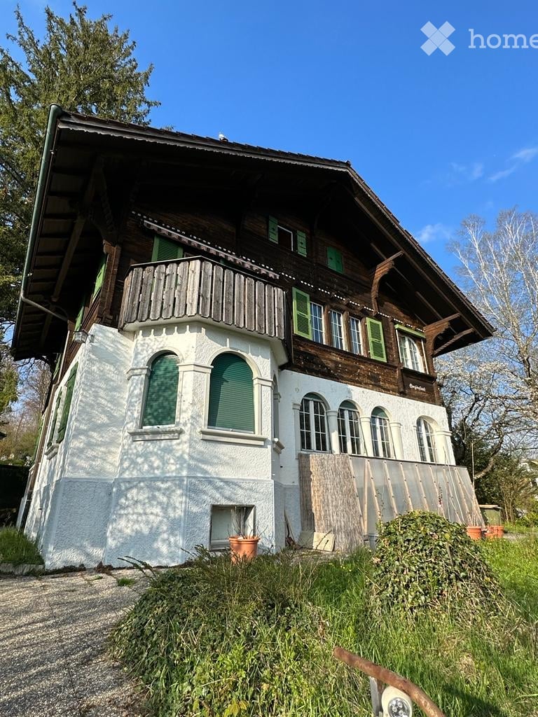 2 story house, wooden exterior, white walls, green shutters, balcony, large windows, driveway