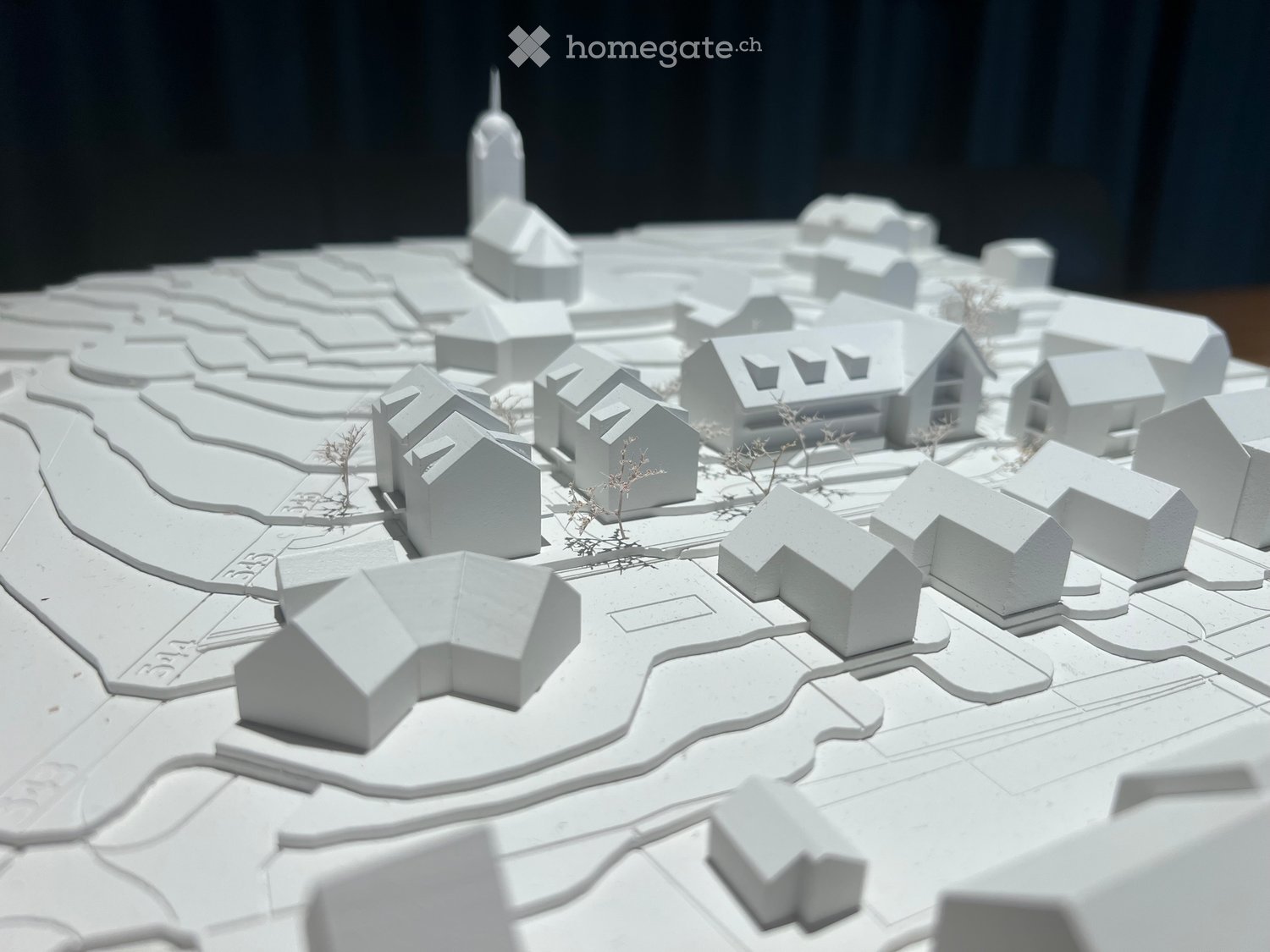 3D model of a small town with multiple houses, pathways, and a central tower-like structure.