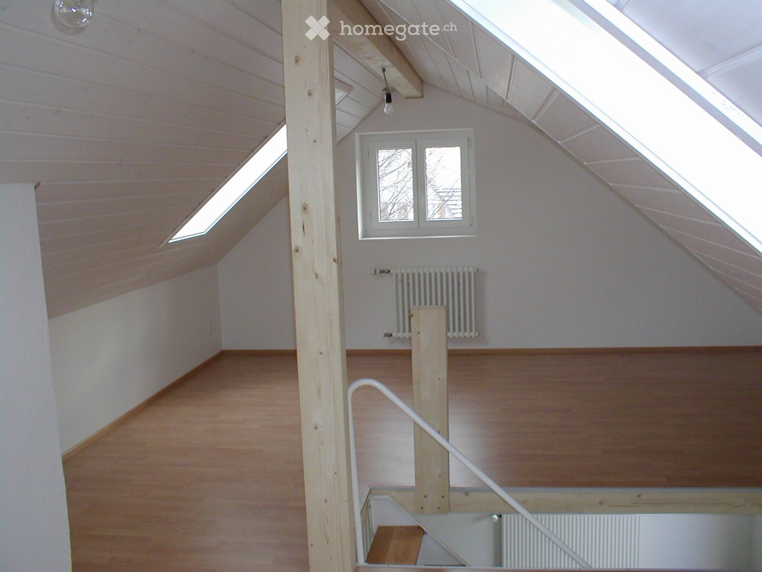 attic room, hardwood floors, white walls, radiator, wooden beams, staircase, skylights
