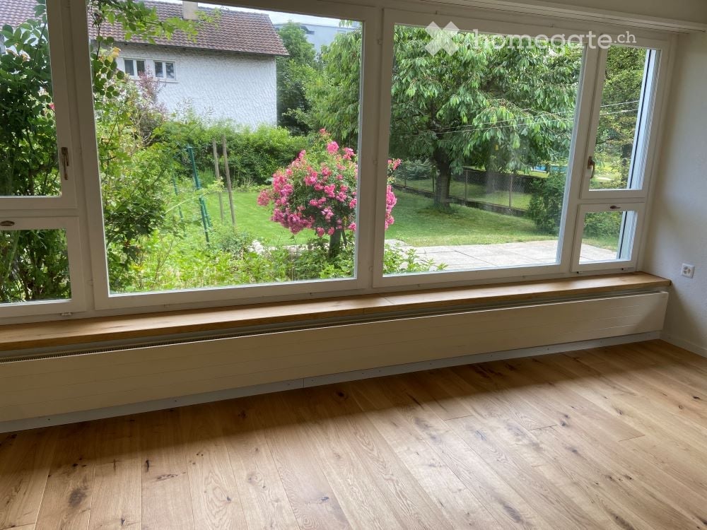 large windows, wooden floor, bench, radiator, garden view