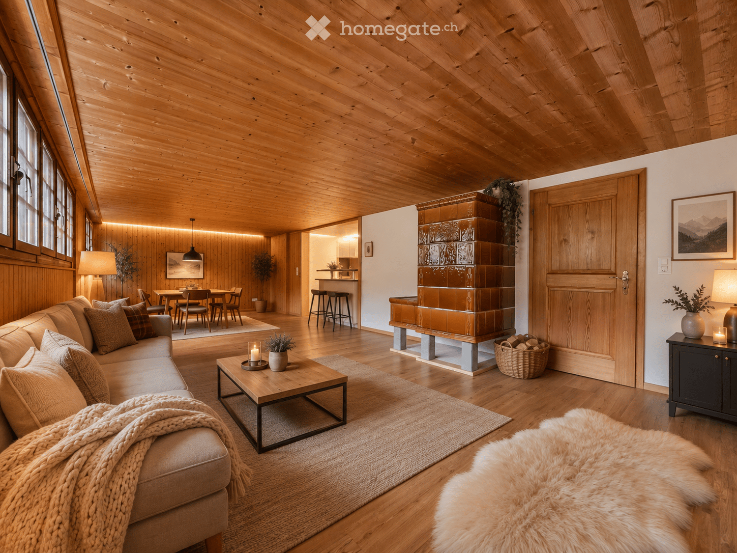 Cozy living room with wooden beams, a fireplace, a sofa, coffee table, side table, and a dining area visible in the background.