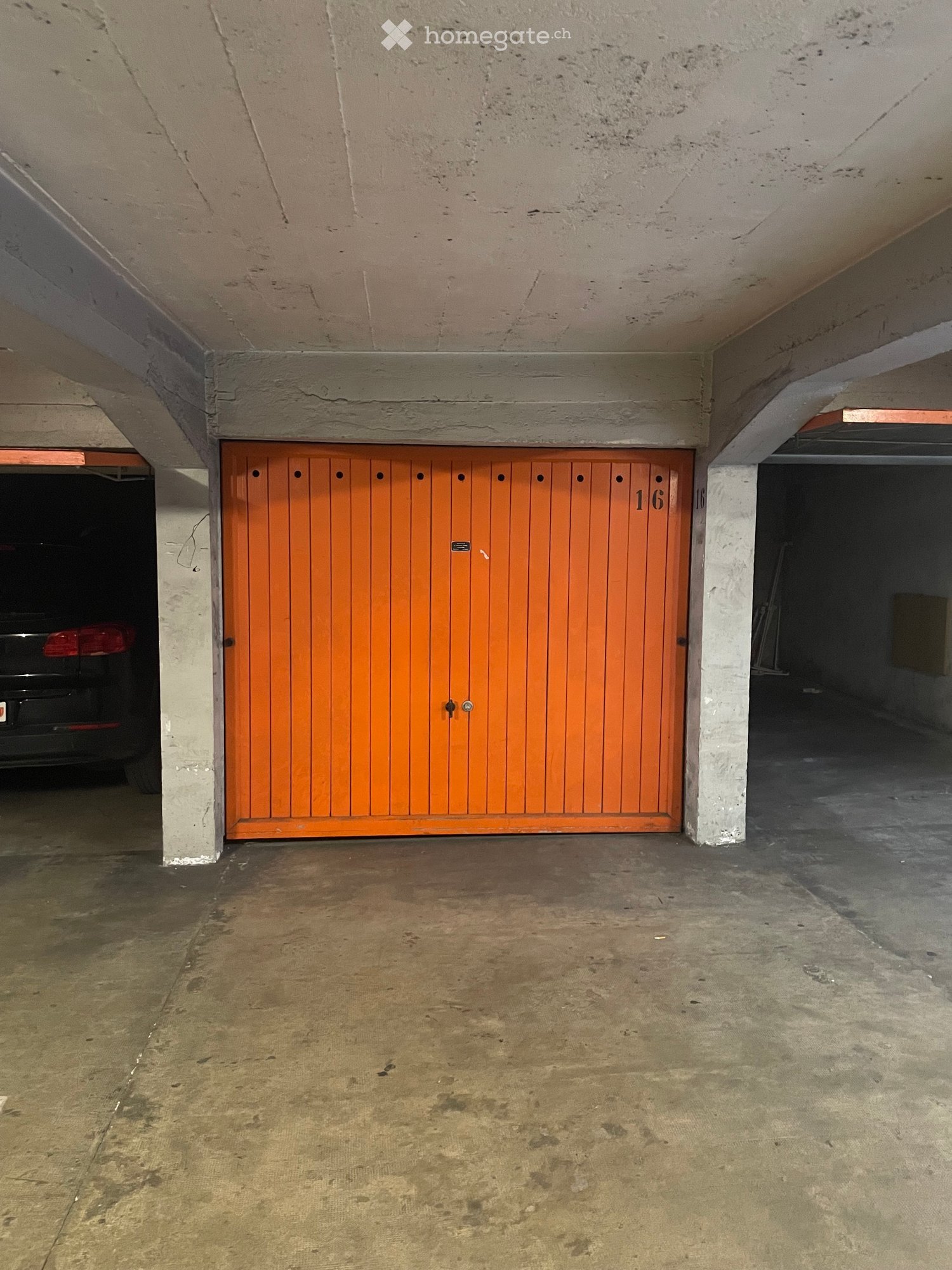 {"visible_features": ["Garage"], "type": "Garage", "objects": [], "description": "Empty underground garage with a closed wooden garage door marked \"16\" and a parked car partially visible behind the door.", "localized_descriptions": {"EN": "Empty undergr