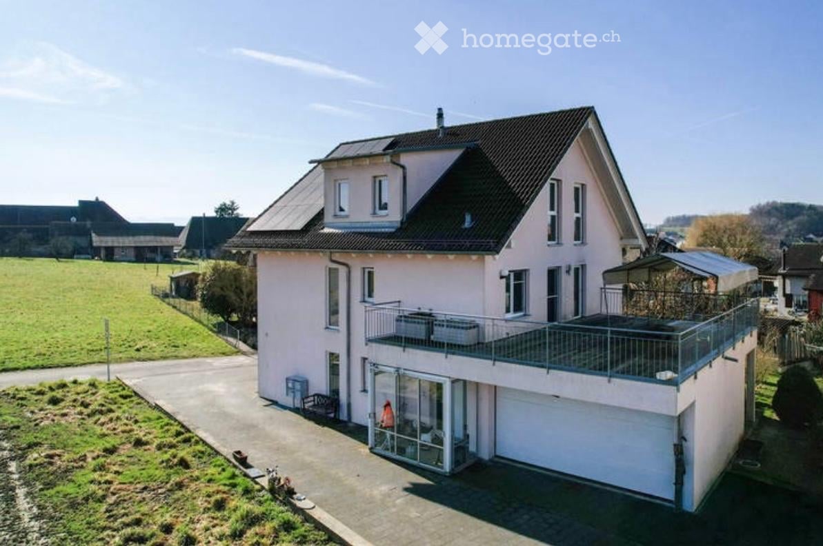 Two-story house with a balcony, garage, and solar panels on the roof.