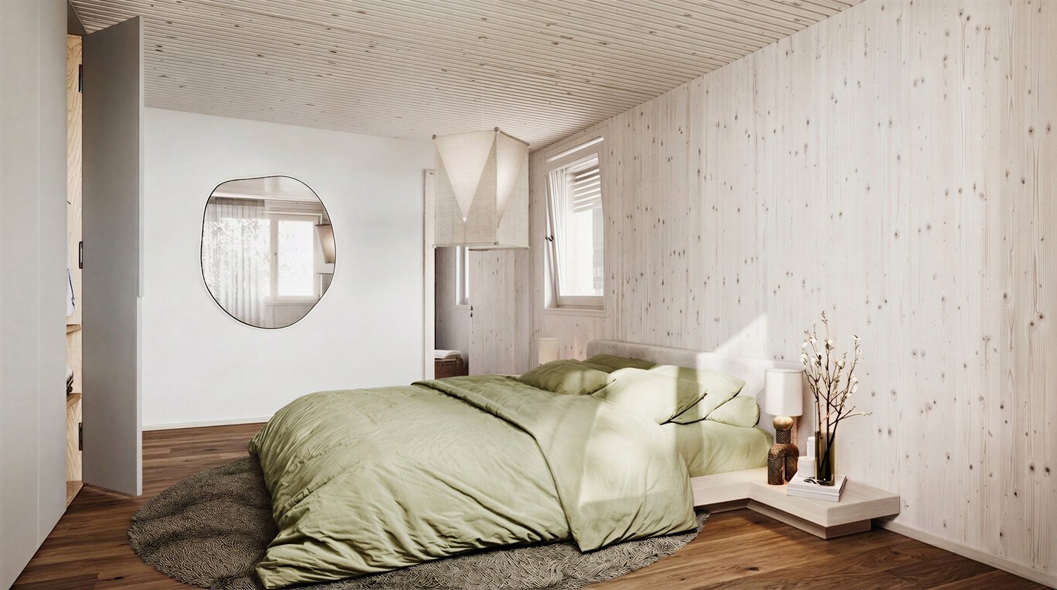Bedroom with wooden floor, white walls, large round mirror, bed with green bedding, nightstand with lamp, rug, and decorative plant.