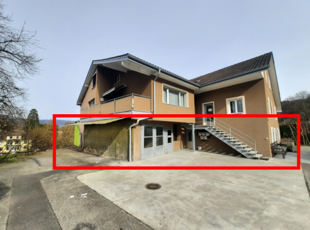 2-story house with a raised ground floor, beige exterior, black roof, balcony, and stairs leading up to the entrance.