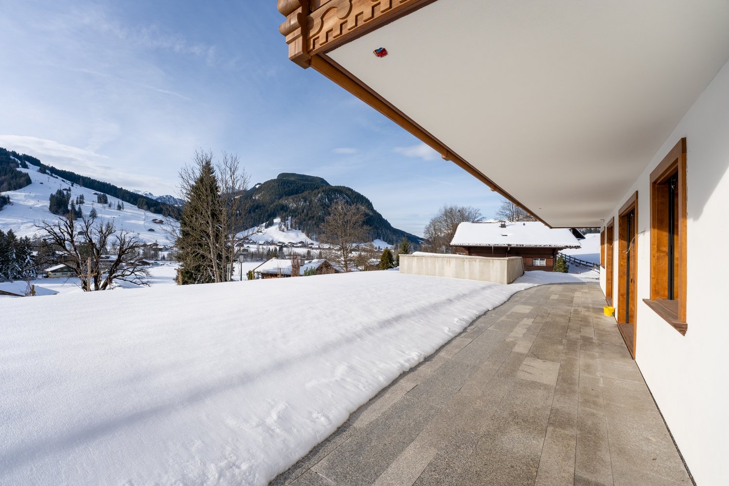 covered terrace with snow, stone flooring, mountains in background