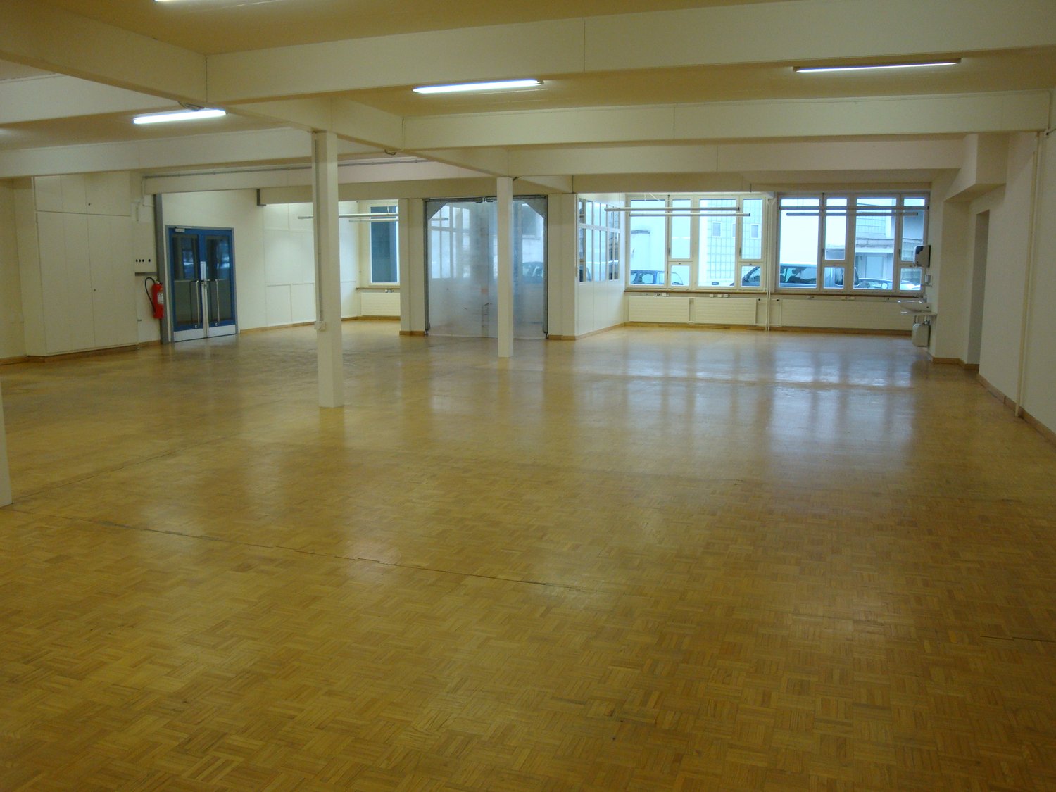 wooden floor, multiple windows, pillars, fire extinguisher