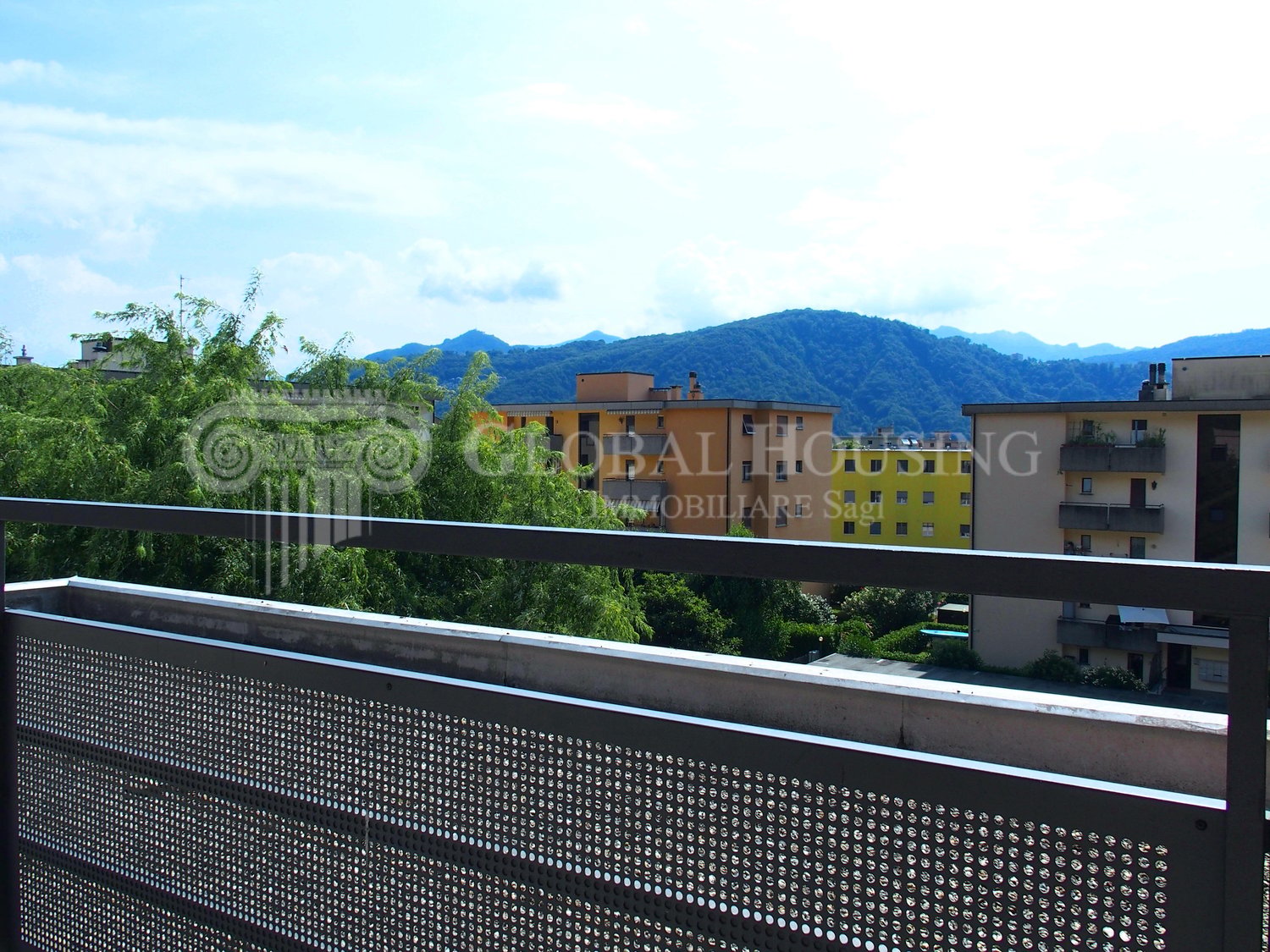 Terrace with metal railing, panoramic view, mountains in the background