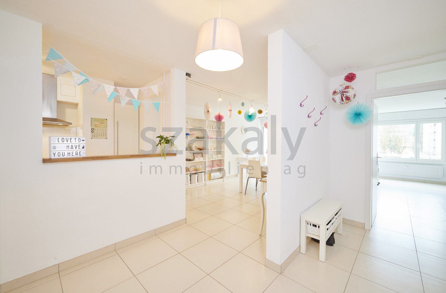 white walls, white tile flooring, white ceiling, white bench, white shelf, decorative items, hanging lamp, open door
