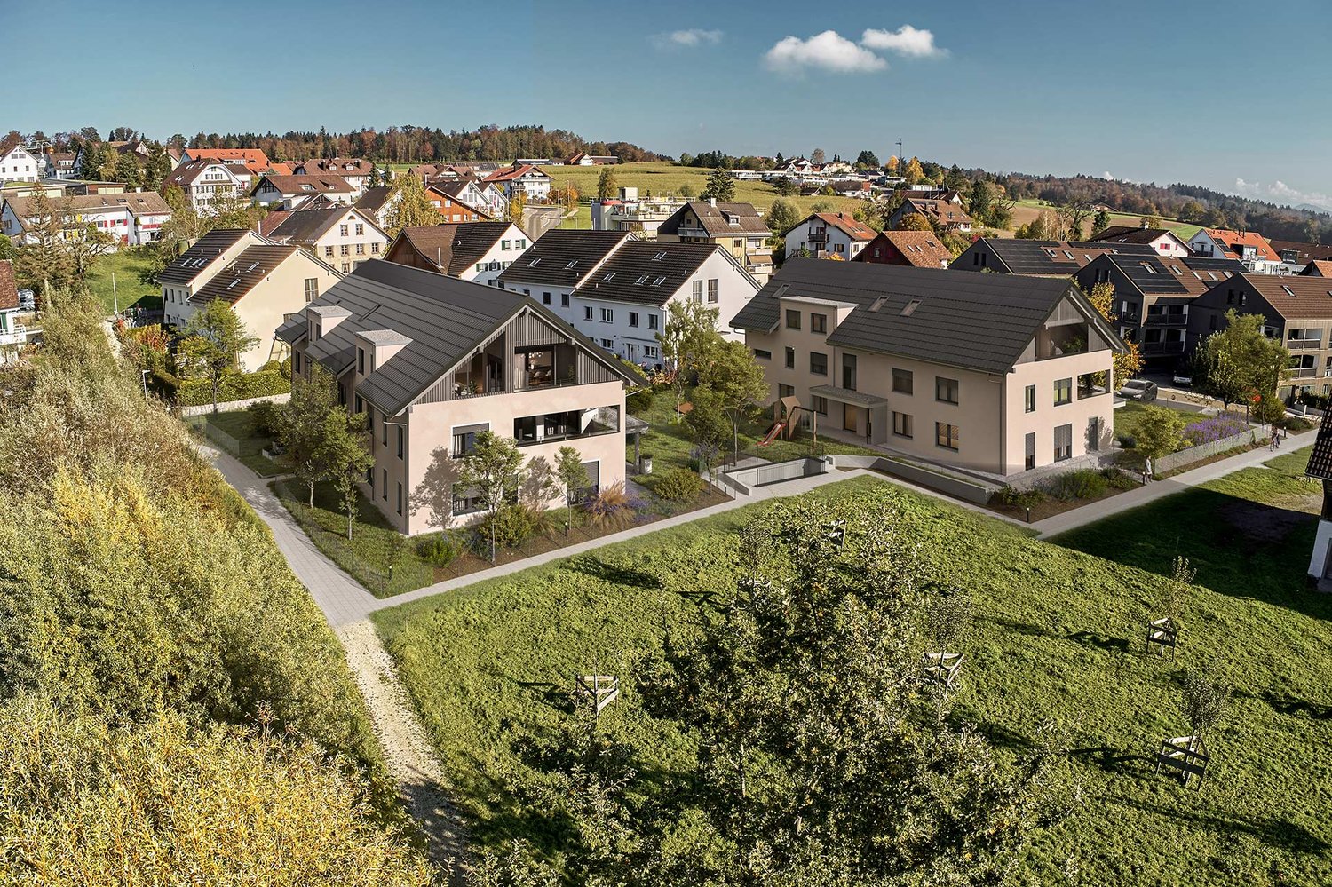 New town area with several modern townhouses surrounded by greenery, paths, and a playground.