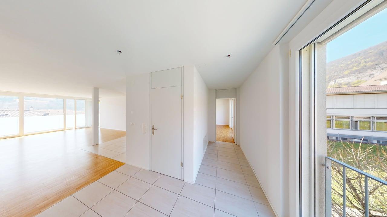 Empty room, white walls, white tiles, wooden floor, large windows, balcony, view of the mountains
