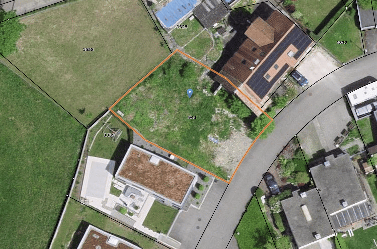 Aerial view of house and adjacent area. Plot with numbers on sides, house with solar panels on the roof.