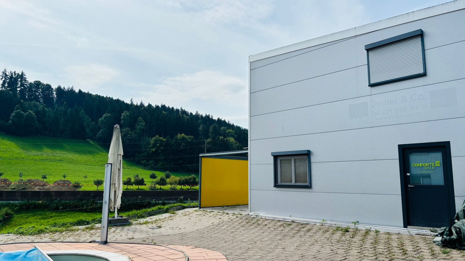 modern style house with large windows, yellow garage, small swimming pool