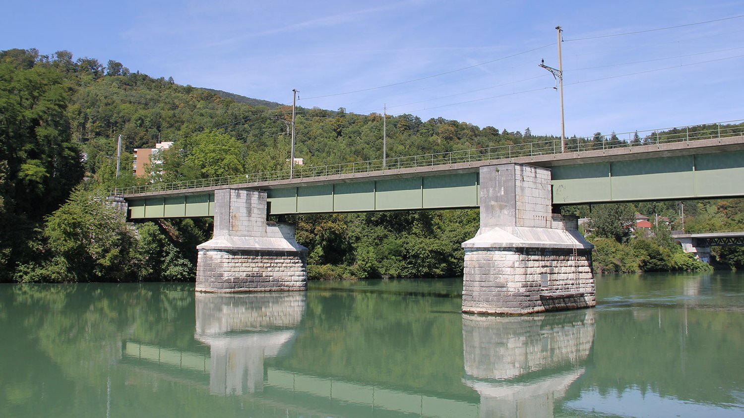 concrete bridge over a river with trees on the side