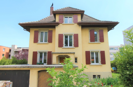 3-story house, yellow exterior, red shutters, wooden front door, visible garage, surrounded by greenery