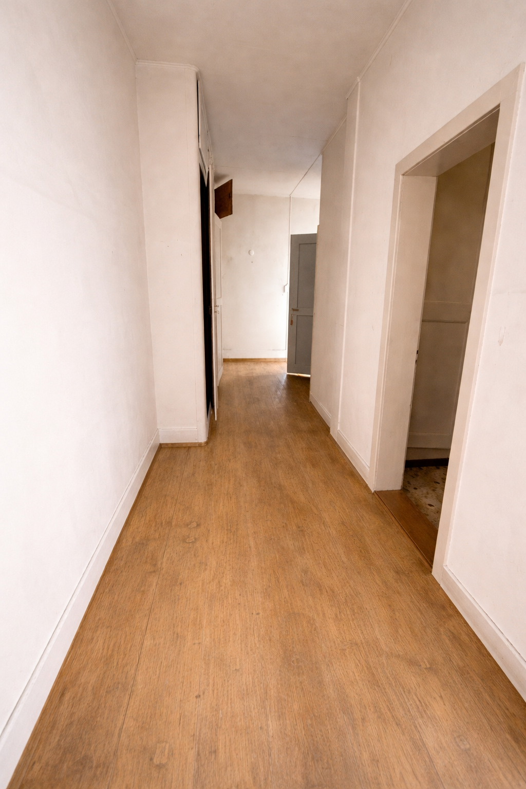 Empty hallway with wooden floor and white walls