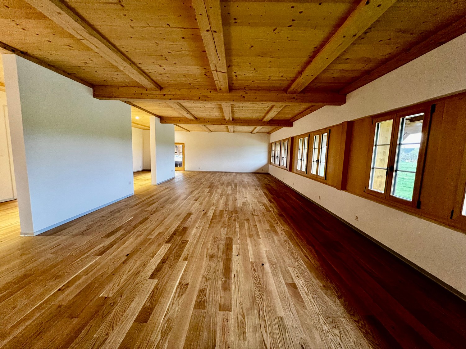 empty room, wooden floor, wooden ceiling, white walls, windows