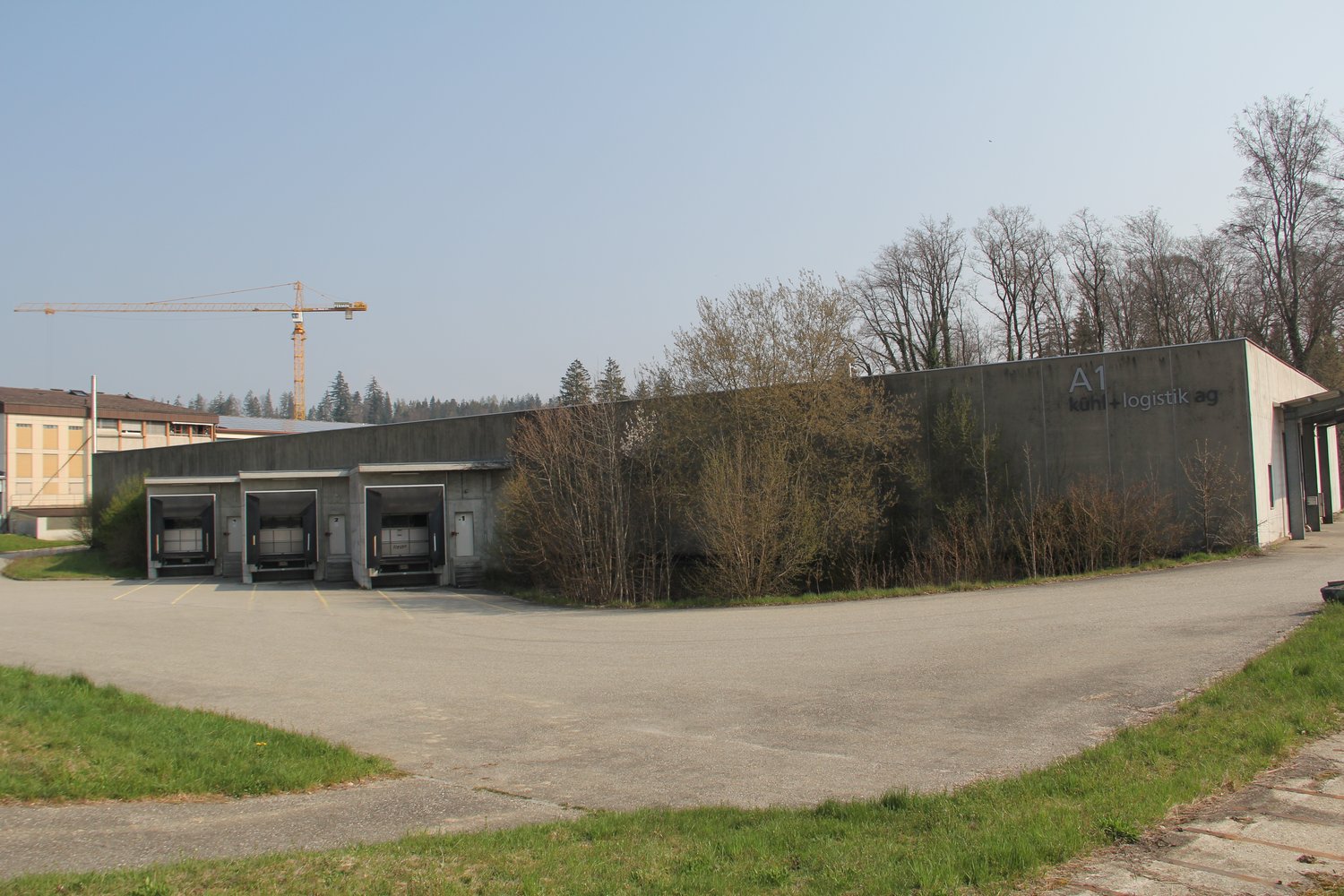 Warehouse building with three loading doors, signage on the wall