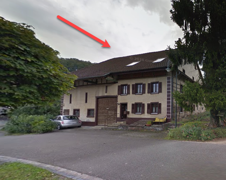 2 story house, brown roof, white windows, brown door, car parked in front