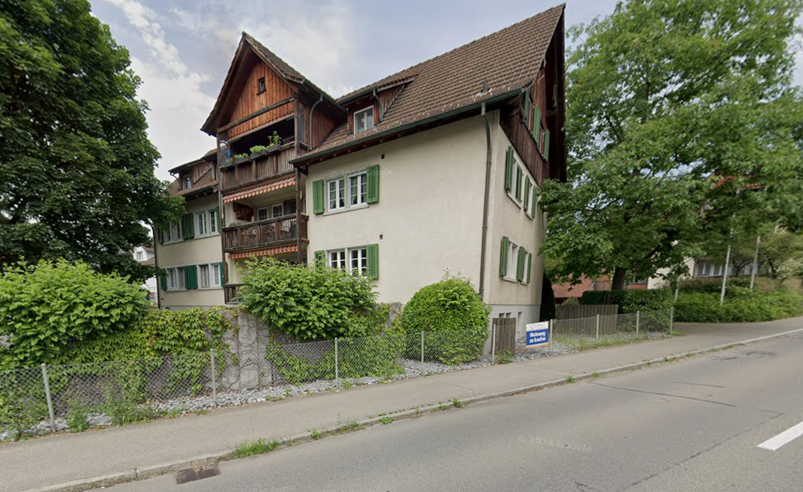 3 story house, brown roof, green shutters, balconies, garden, fence