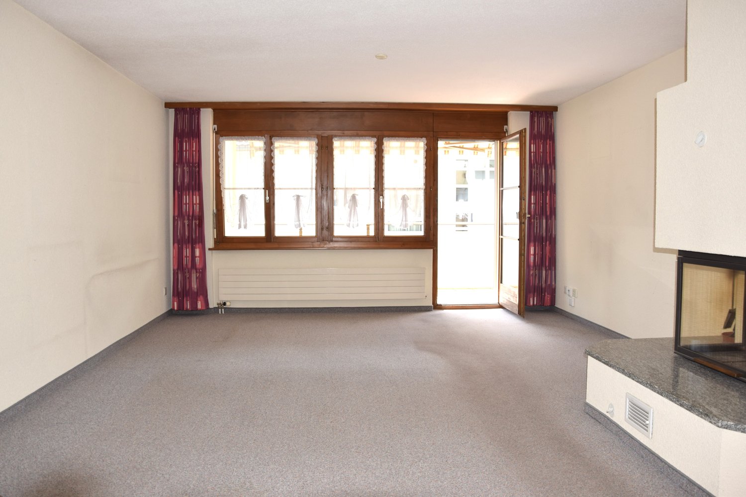 empty room, fireplace, large windows, sliding door, carpeted floor