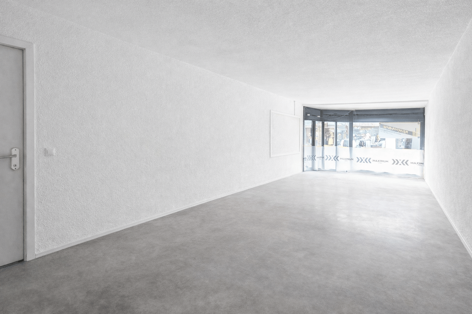 white walls, grey carpet, open door leading to outside, large windows