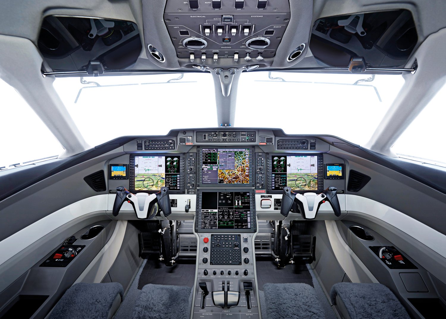 Cockpit dashboard with monitors, control panels, switches, and gauges.