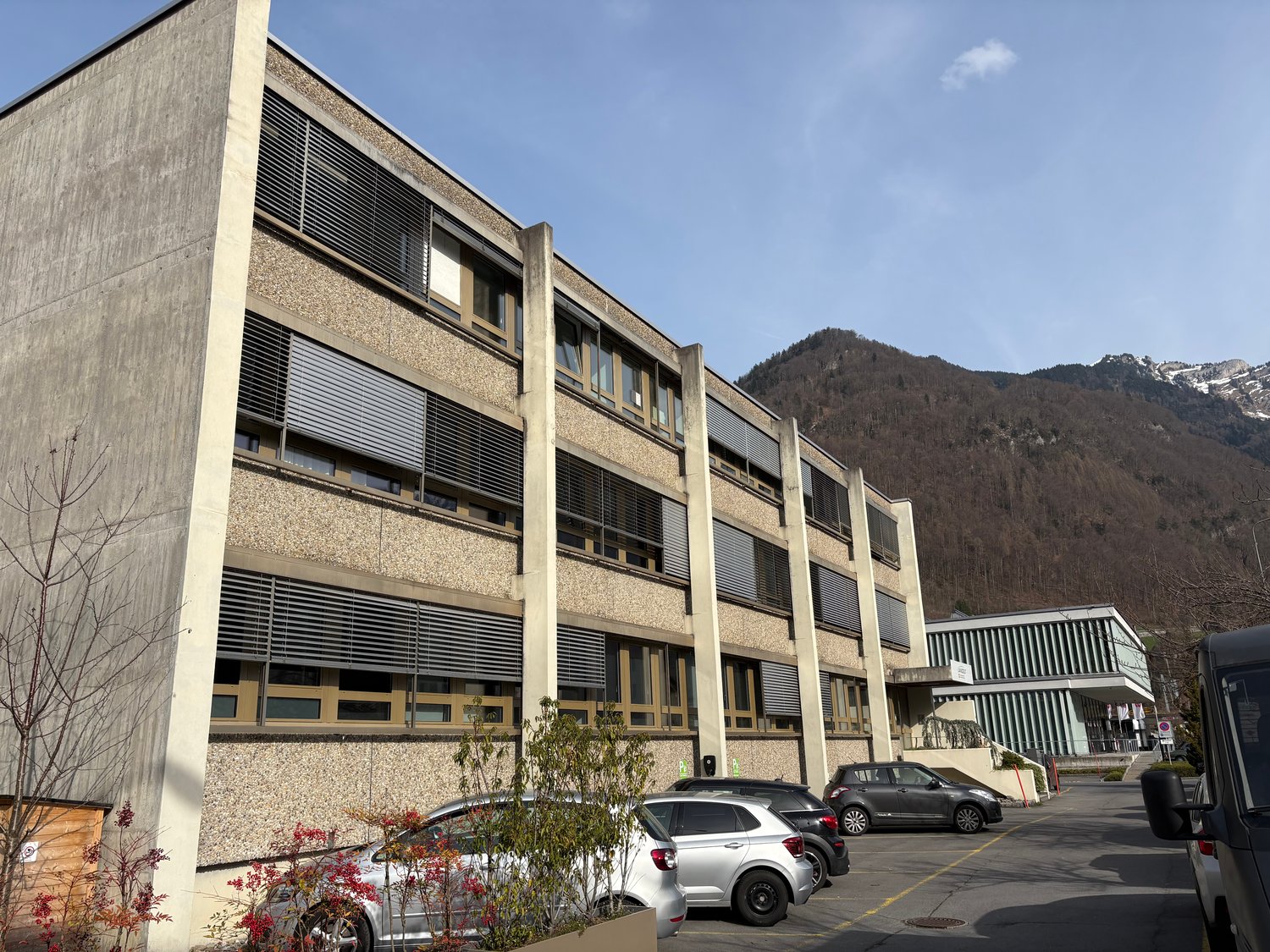 large modern building, parking, surrounded by mountains